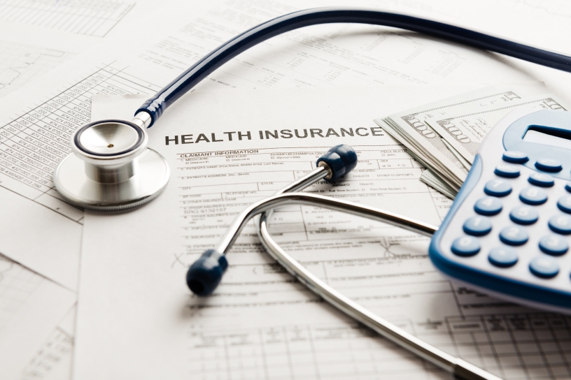 Stethoscope and calculator over a health insurance claim